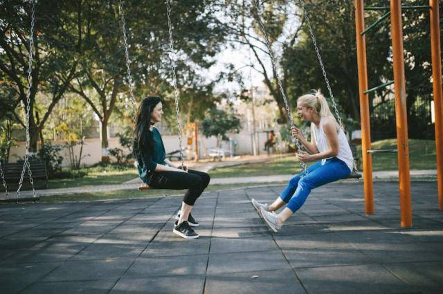 two young women on a swing set