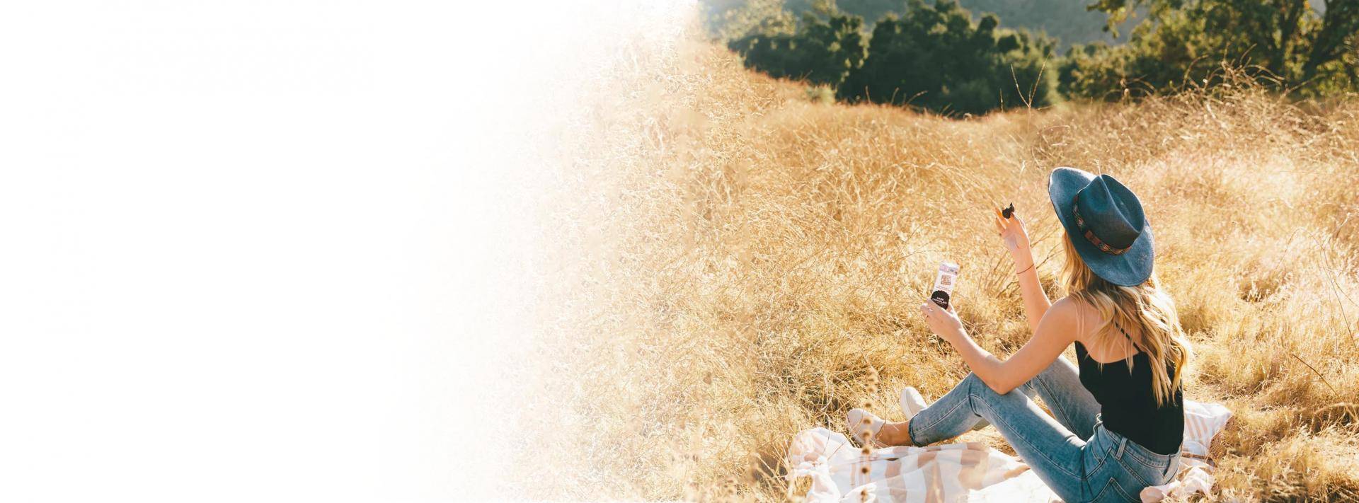 woman sitting on blanket in field 