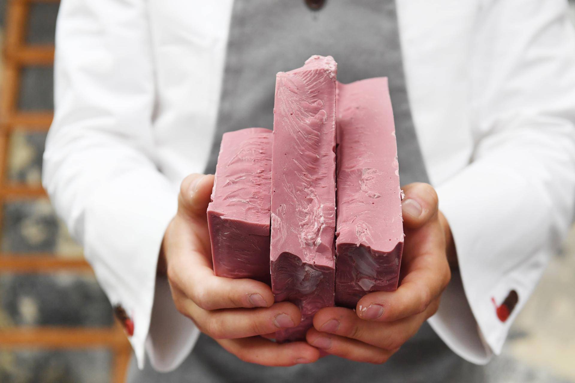 Chef holding 3 blocks of Ruby chocolate