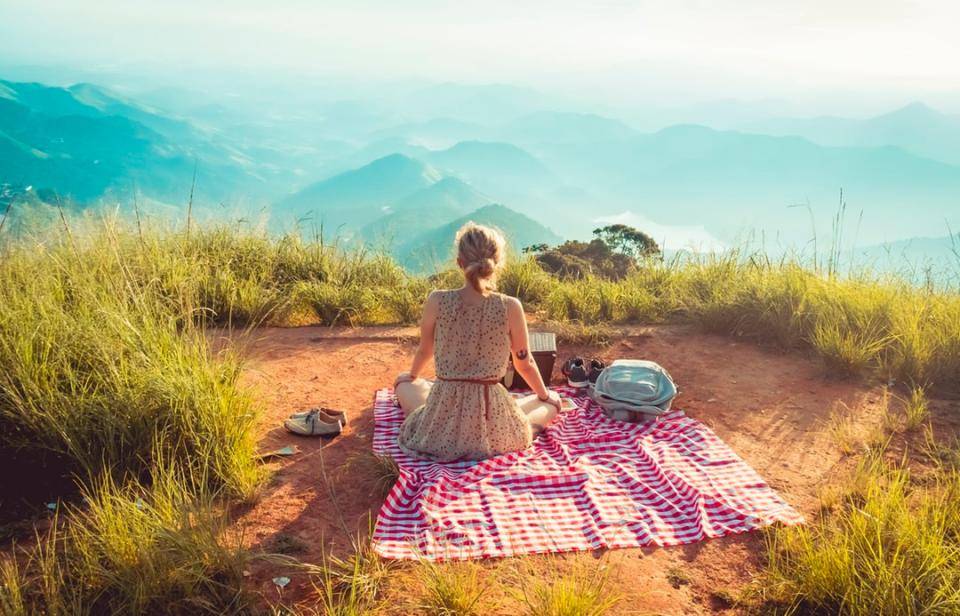 woman sitting on blanket looking out onto horizon