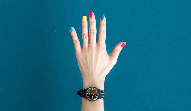 woman's hand with nail polish over a blue background